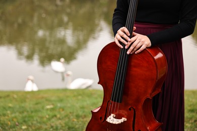 Photo of Woman with cello in park, closeup. Space for text