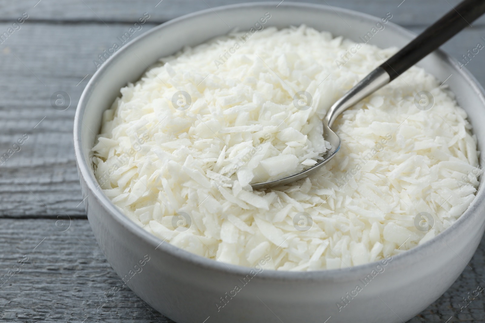 Photo of Soy wax in bowl on grey wooden table