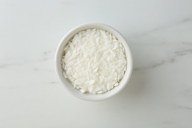 Photo of Soy wax in bowl on white marble table, top view