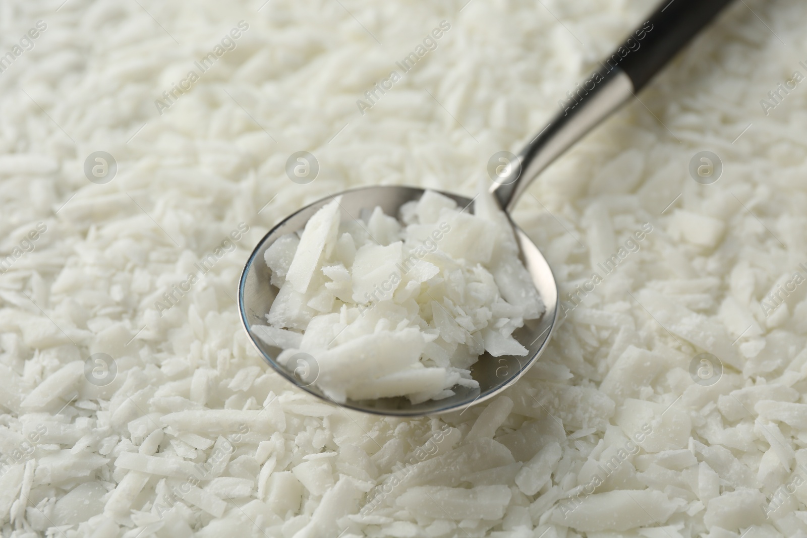 Photo of Soy wax in spoon on pile, closeup