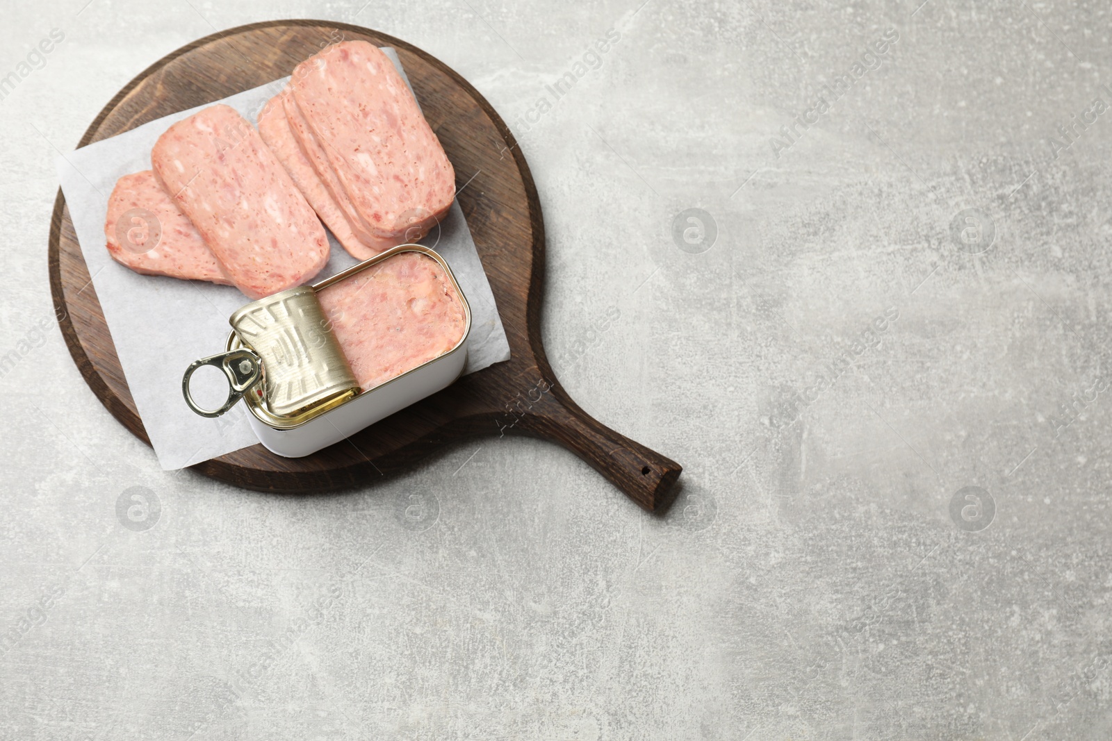 Photo of Tasty canned meat on grey table, top view. Space for text