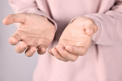 Photo of Man holding something on grey background, closeup