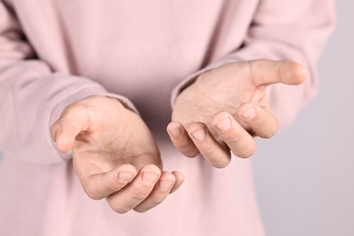 Man holding something on grey background, closeup