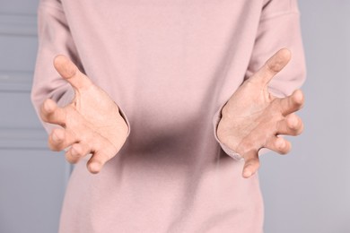 Photo of Man holding something on grey background, closeup