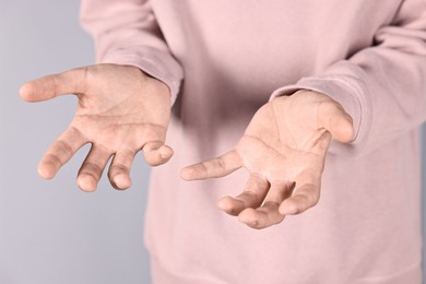 Photo of Man holding something on grey background, closeup