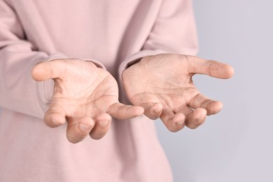 Photo of Man holding something on grey background, closeup