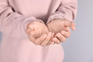 Photo of Man holding something on grey background, closeup