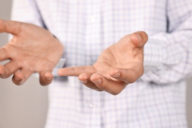 Photo of Man holding something on grey background, closeup