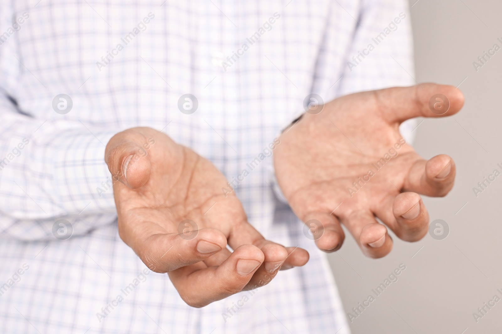 Photo of Man holding something on grey background, closeup