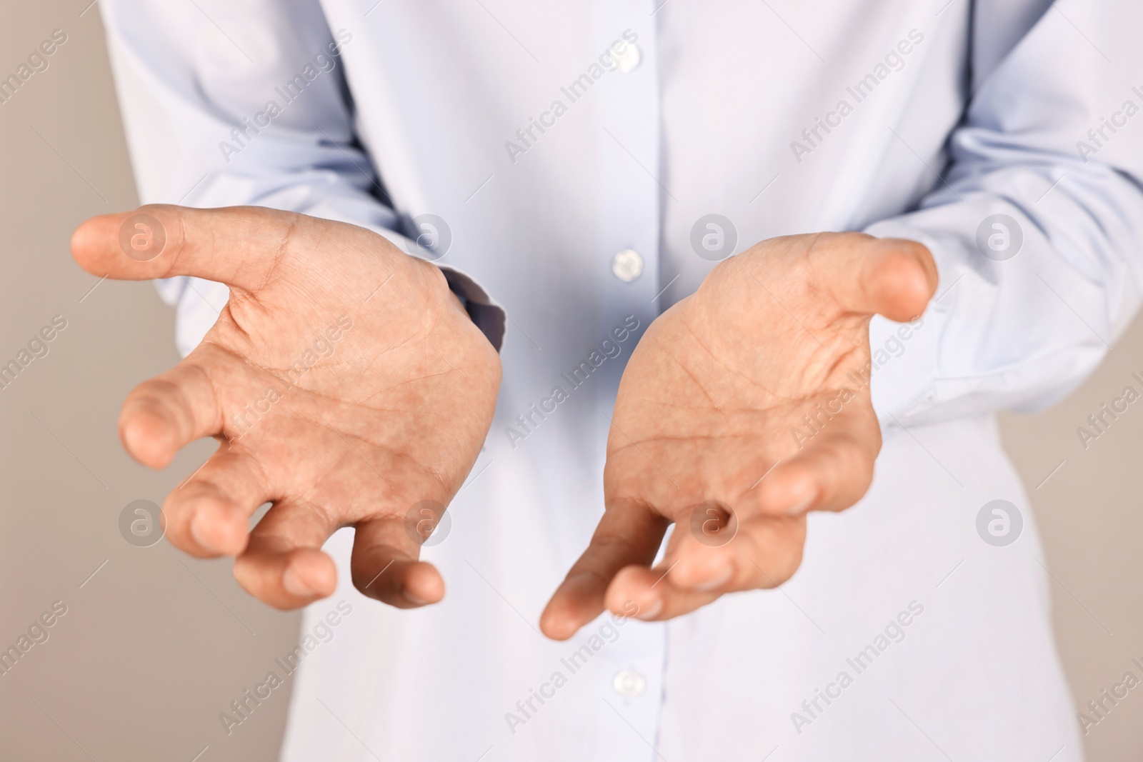 Photo of Man holding something on grey background, closeup