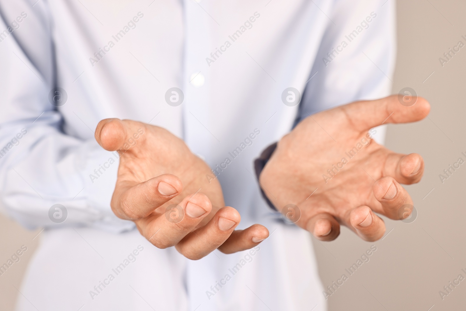 Photo of Man holding something on grey background, closeup