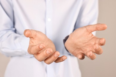 Photo of Man holding something on grey background, closeup