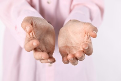 Photo of Man holding something on light background, closeup