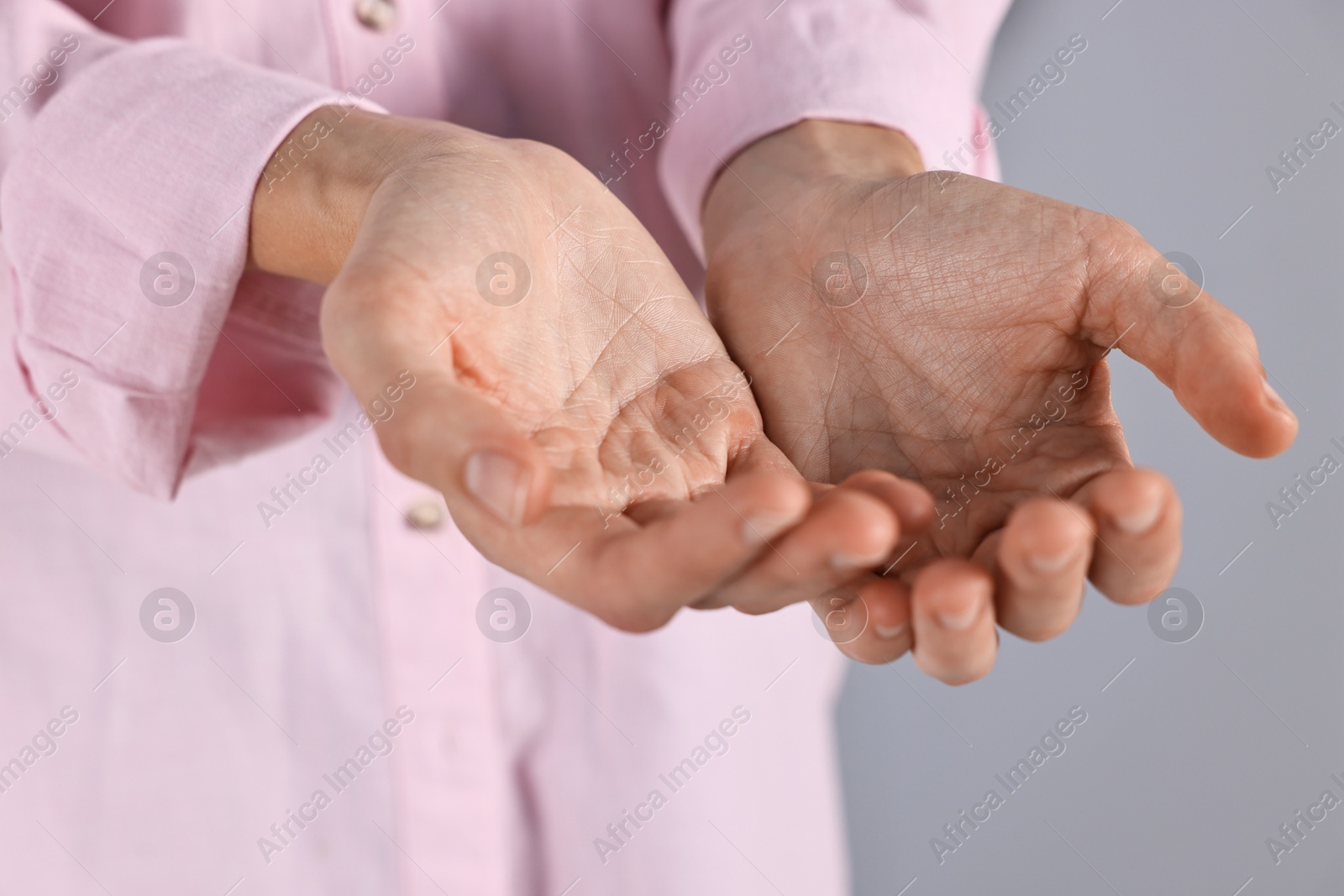 Photo of Man holding something on grey background, closeup