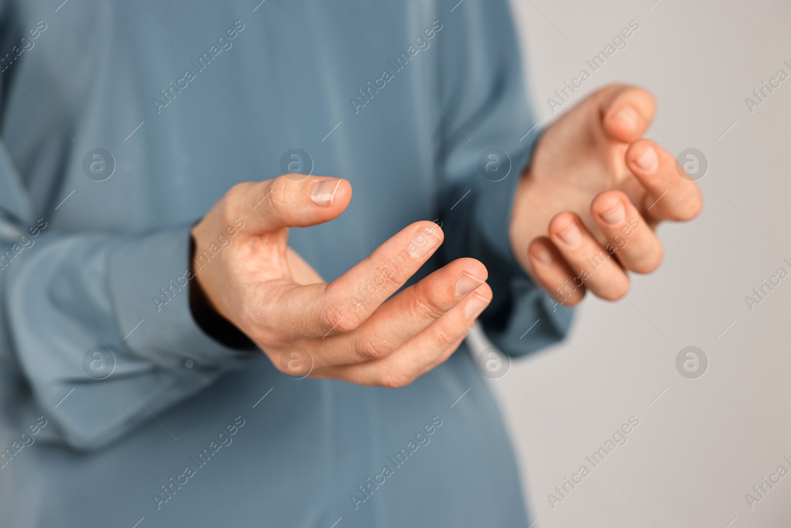 Photo of Man holding something on grey background, closeup