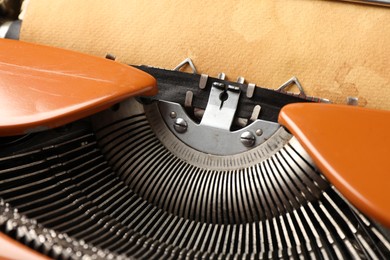 Photo of Vintage typewriter with sheet of parchment paper, closeup