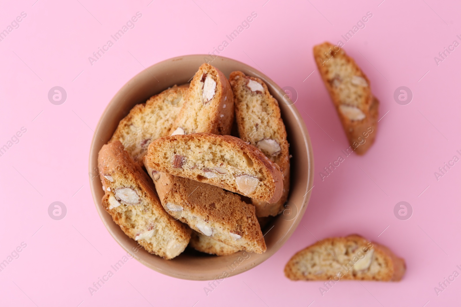 Photo of Tasty almond biscuits (Cantuccini) on pink background, flat lay