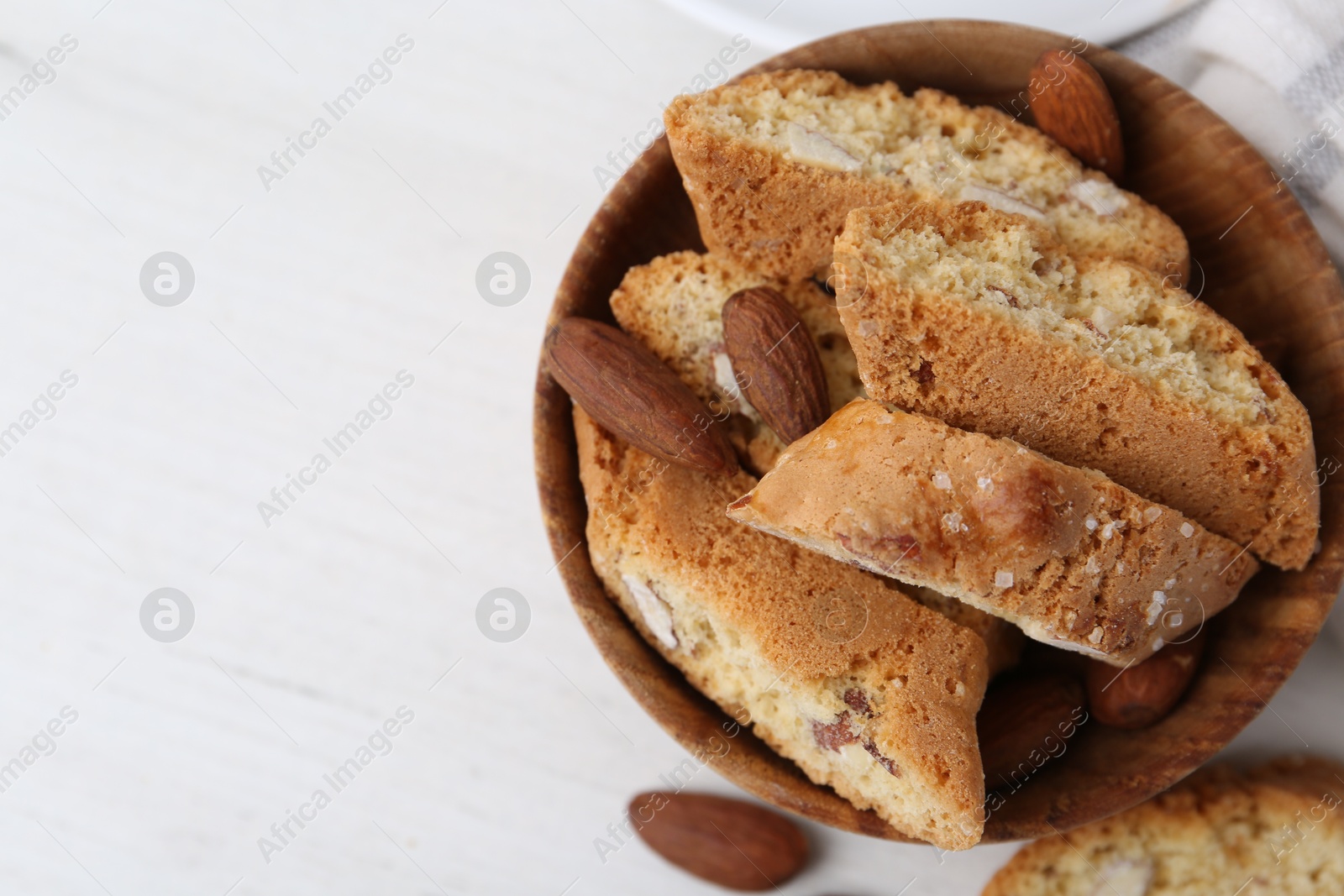 Photo of Tasty almond biscuits (Cantuccini) and nuts on white table, flat lay. Space for text