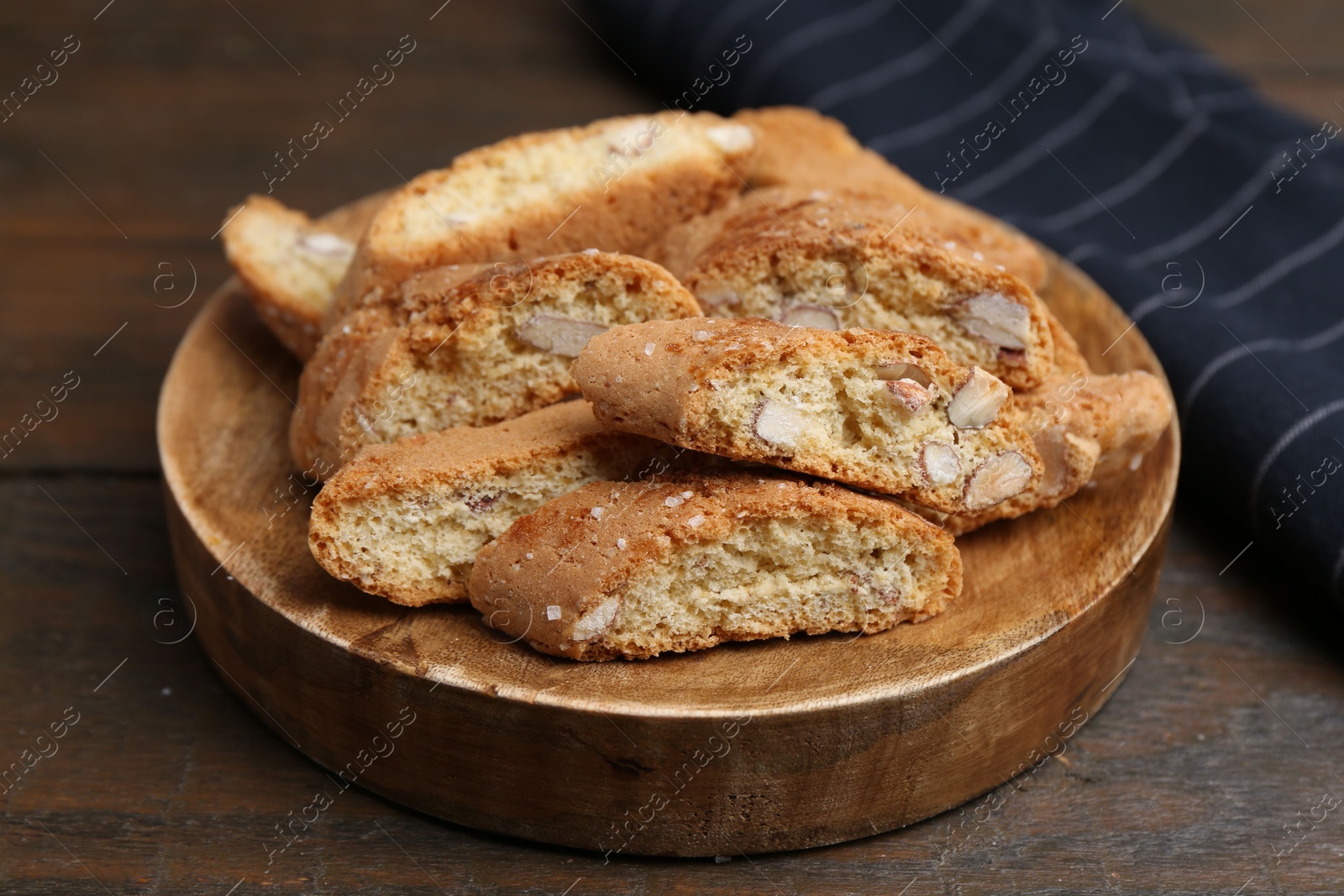 Photo of Tasty almond biscuits (Cantuccini) on wooden table, closeup