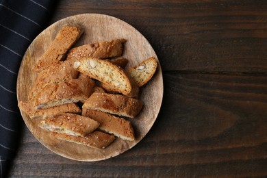 Photo of Tasty almond biscuits (Cantuccini) on wooden table, top view. Space for text