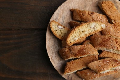 Photo of Tasty almond biscuits (Cantuccini) on wooden table, top view. Space for text