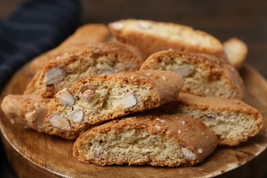 Photo of Tasty almond biscuits (Cantuccini) on wooden board, closeup