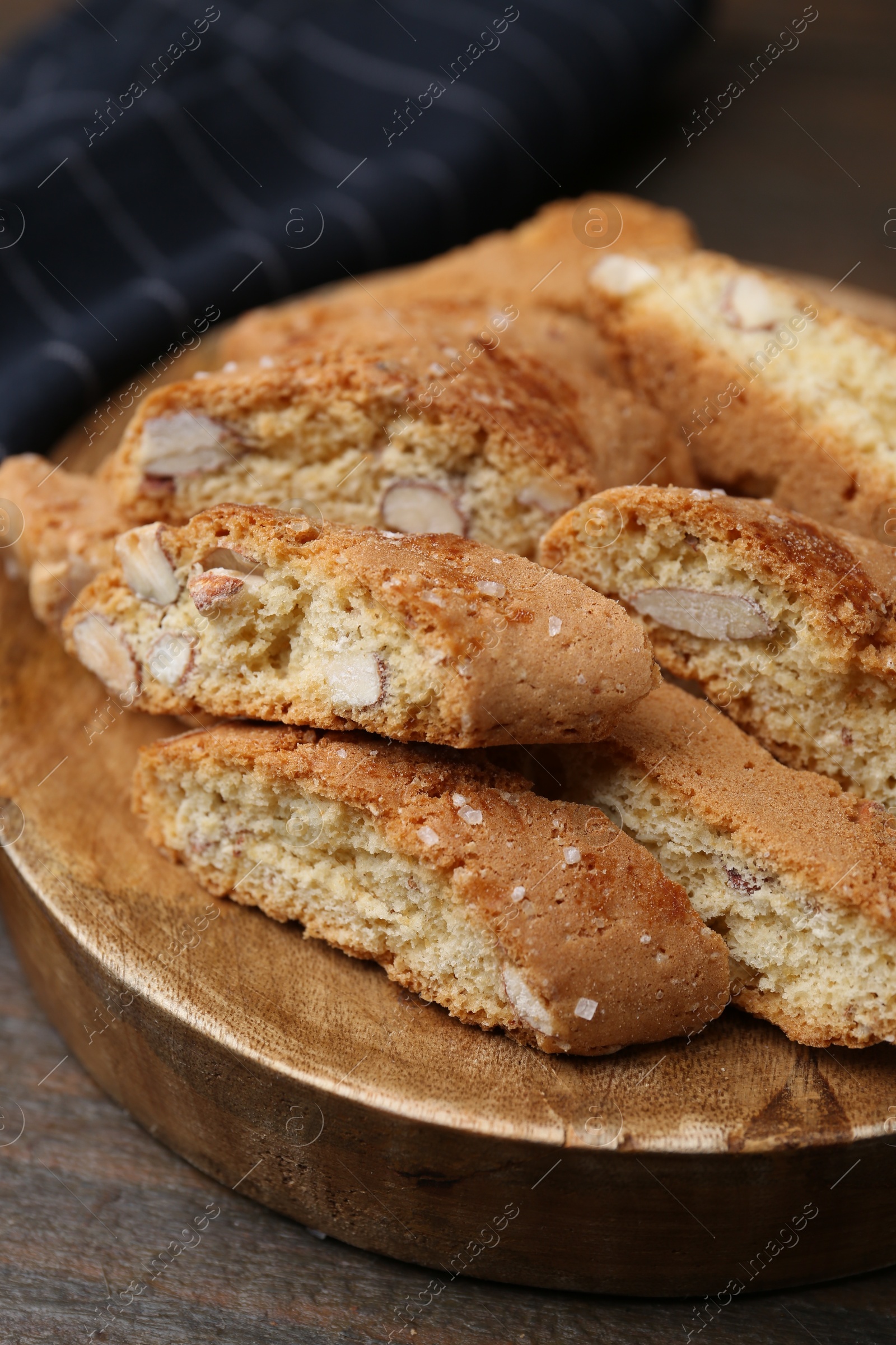 Photo of Tasty almond biscuits (Cantuccini) on wooden table, closeup