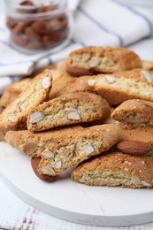 Photo of Tasty almond biscuits (Cantuccini) and nuts on white wooden table, closeup