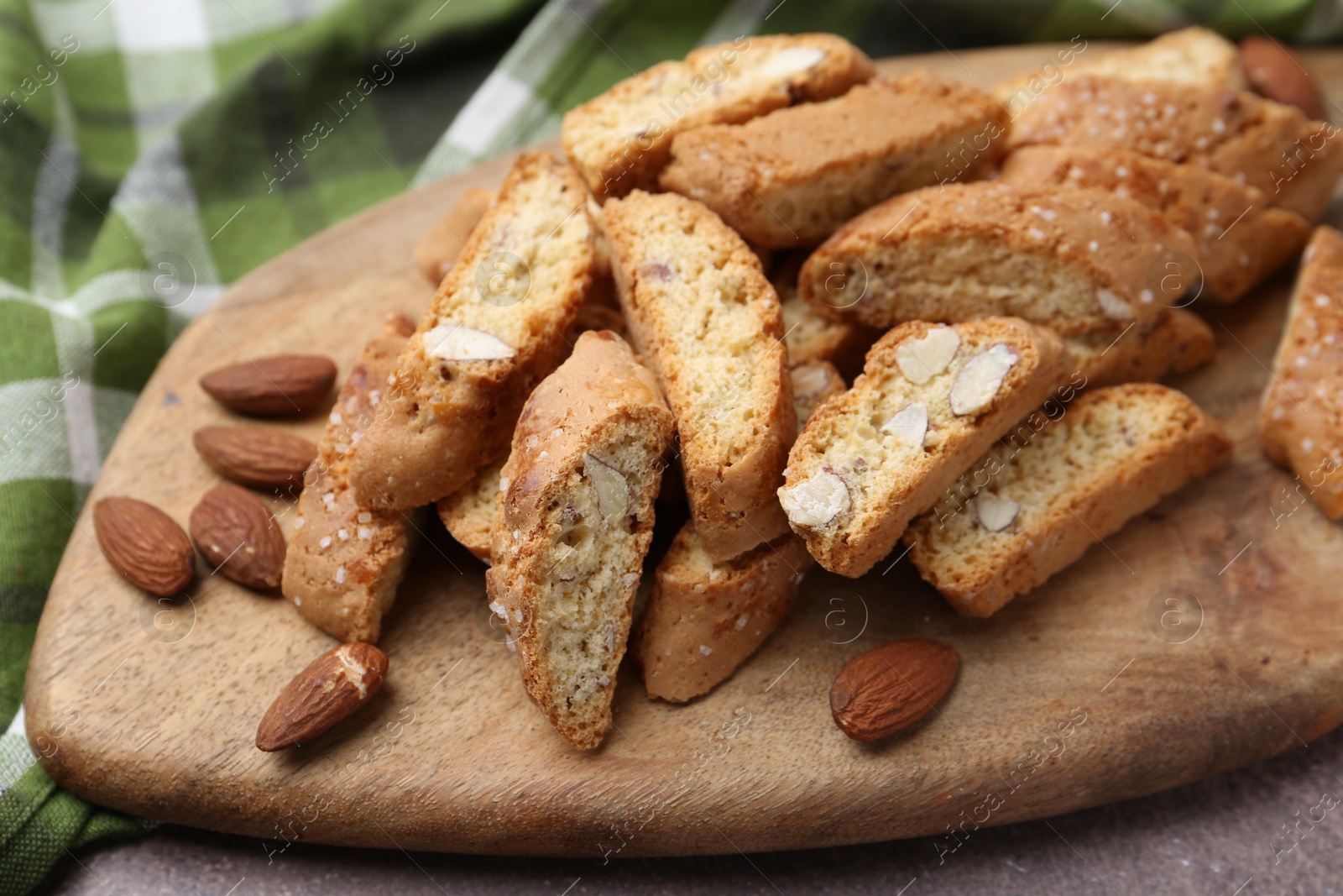 Photo of Tasty almond biscuits (Cantuccini) and nuts on table, closeup