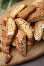 Photo of Tasty almond biscuits (Cantuccini) and nuts on brown table, above view