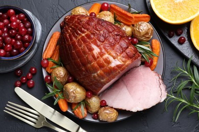 Photo of Christmas food. Tasty baked ham served on black table, flat lay