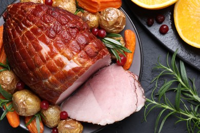 Photo of Christmas food. Tasty baked ham served on black table, flat lay