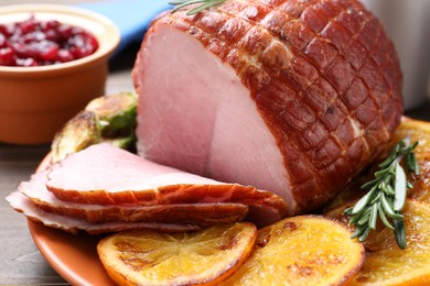 Photo of Christmas food. Tasty baked ham served on wooden table, closeup