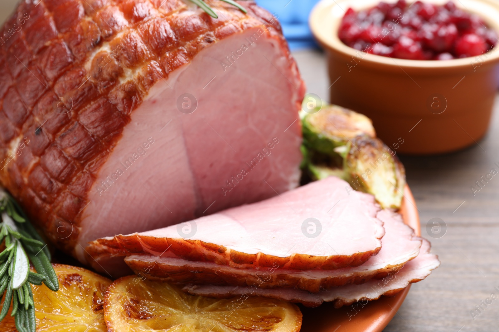 Photo of Christmas food. Tasty baked ham served on wooden table, closeup