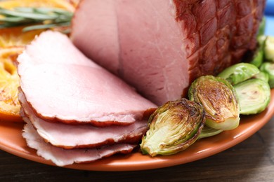 Photo of Christmas food. Tasty baked ham served on wooden table, closeup