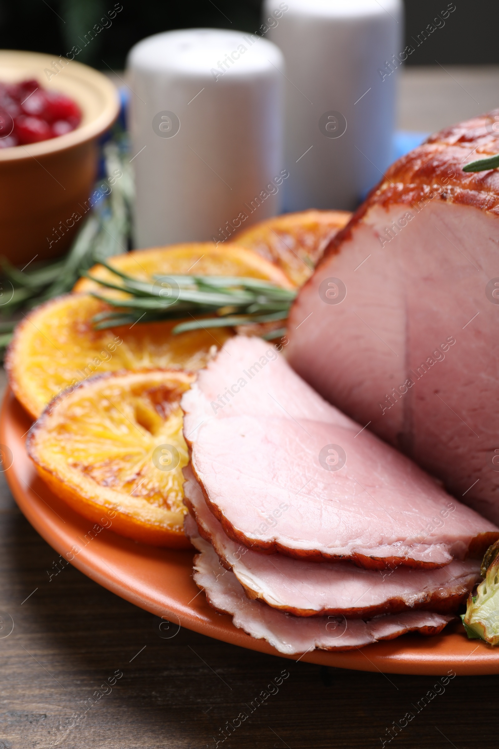 Photo of Christmas food. Tasty baked ham served on wooden table, closeup