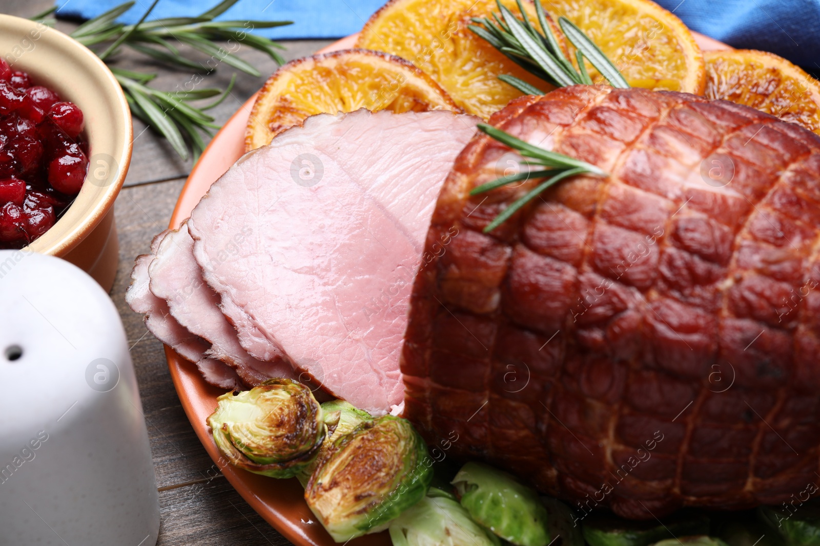 Photo of Christmas food. Tasty baked ham served on wooden table, closeup