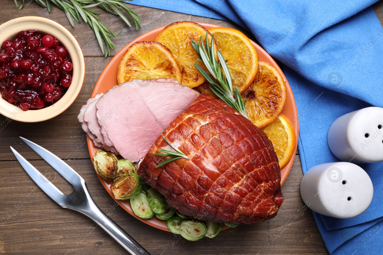 Photo of Christmas food. Tasty baked ham served on wooden table, flat lay