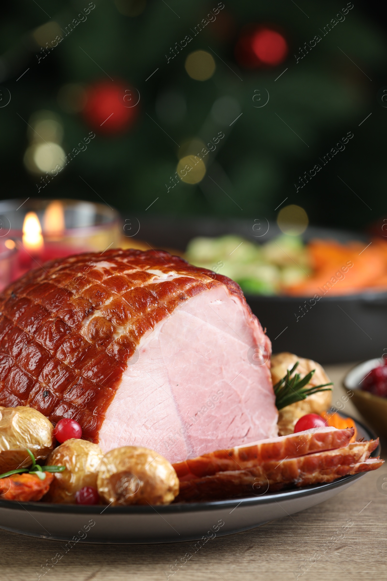 Photo of Christmas food. Tasty baked ham served on wooden table, closeup