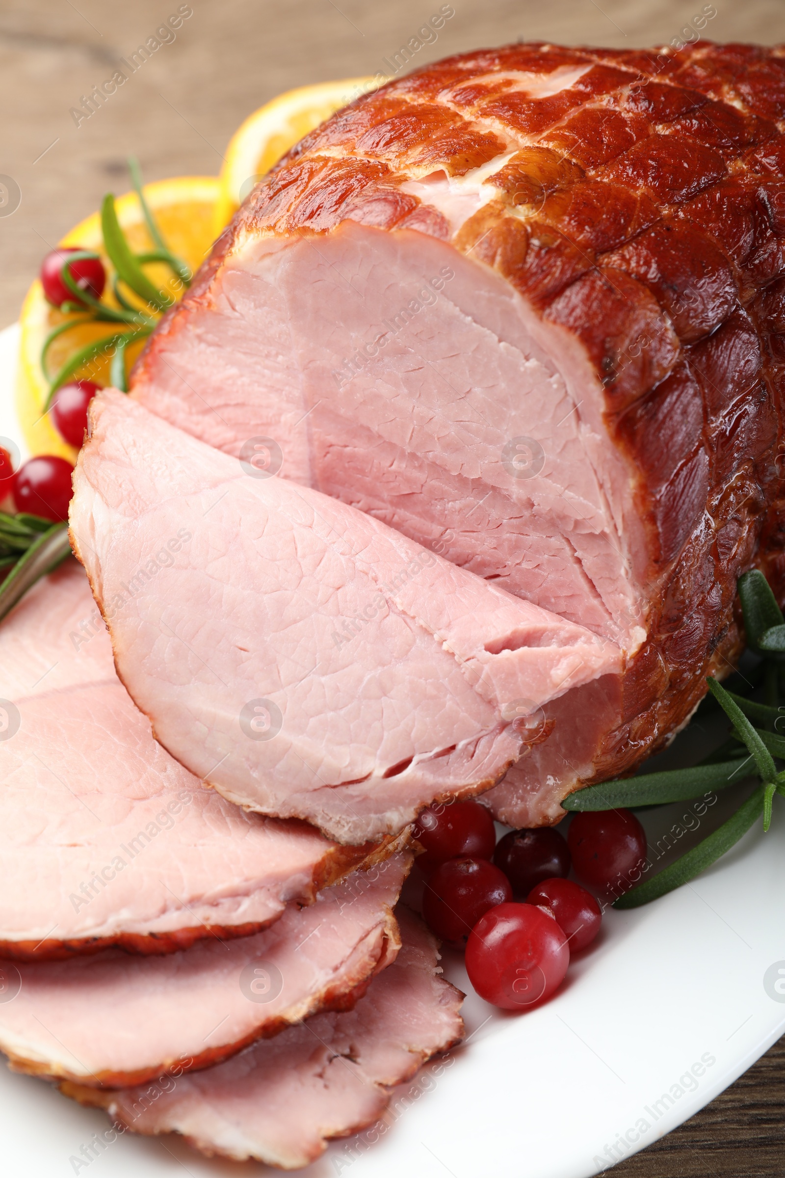 Photo of Christmas food. Tasty baked ham served on wooden table, closeup