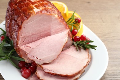 Photo of Christmas food. Tasty baked ham served on wooden table, closeup