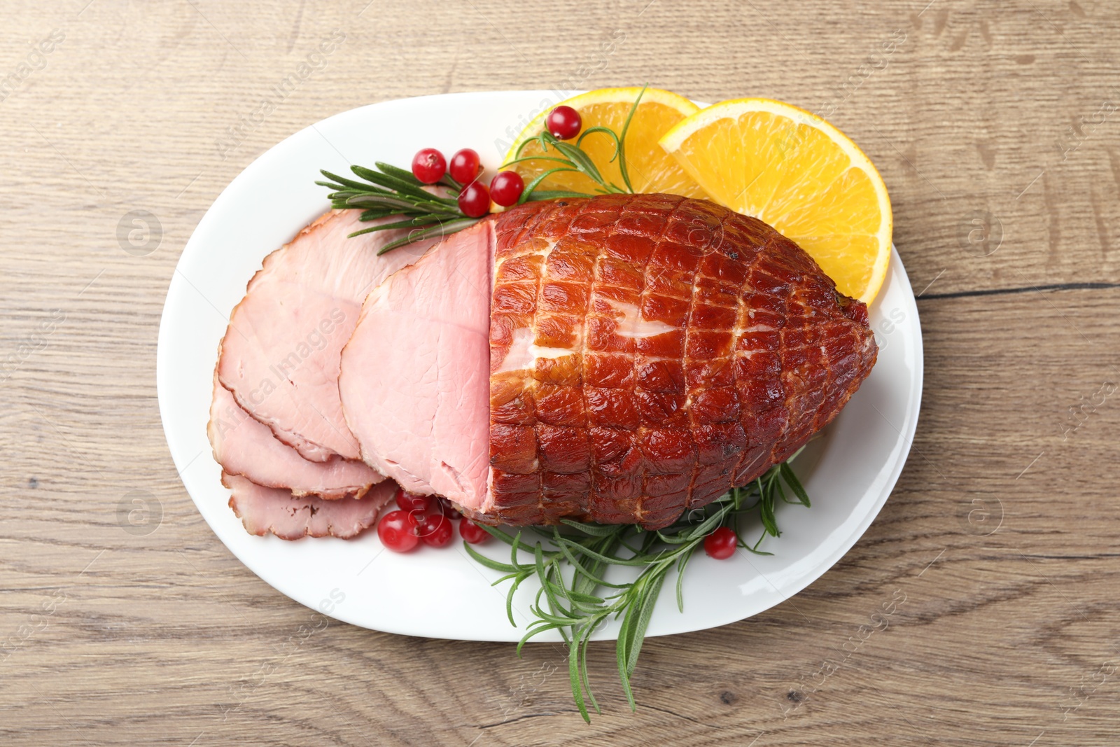 Photo of Christmas food. Tasty baked ham served on wooden table, top view