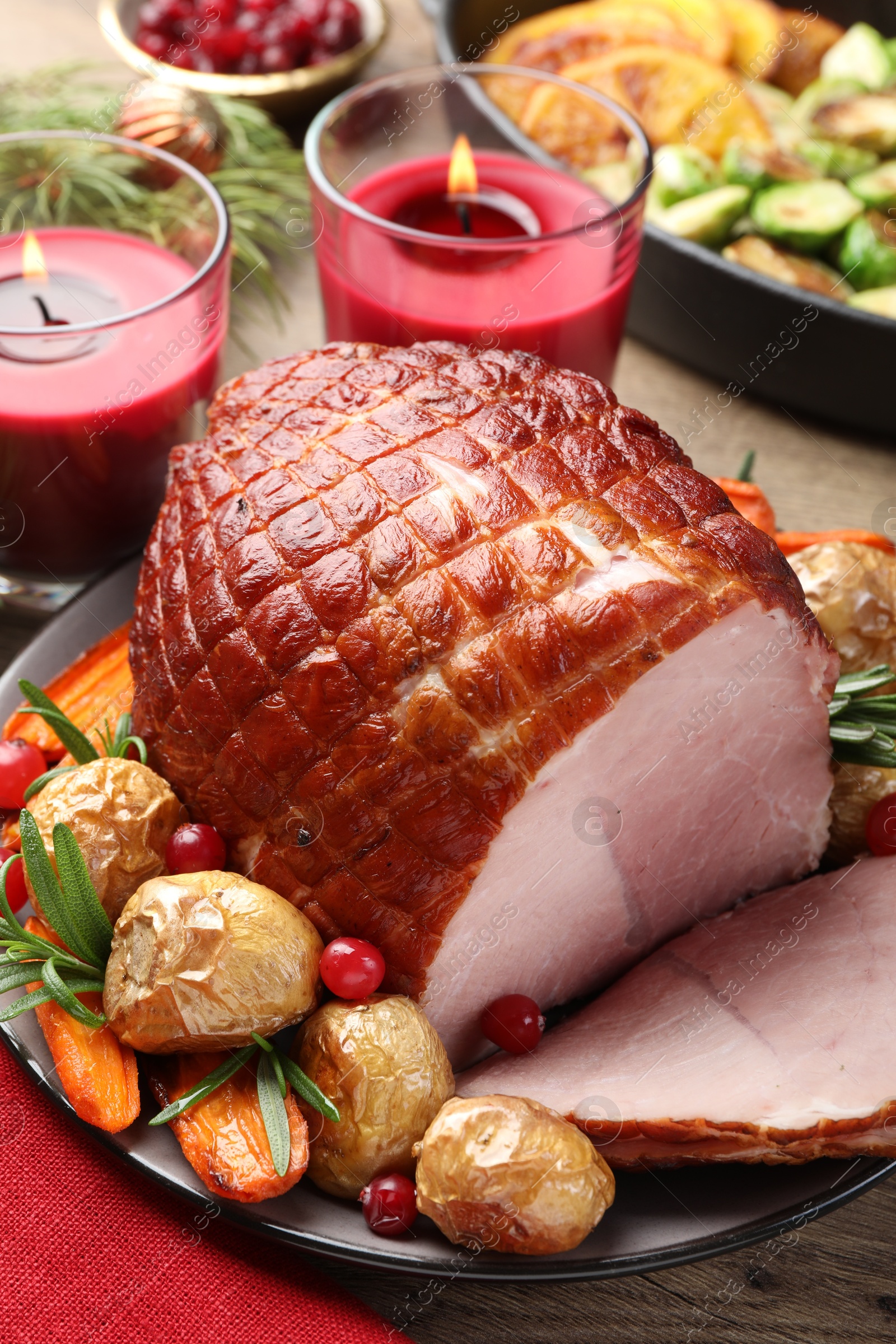 Photo of Christmas food. Tasty baked ham served on wooden table, closeup