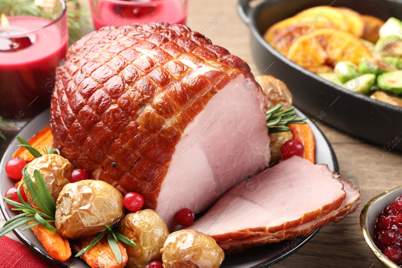 Photo of Christmas food. Tasty baked ham served on wooden table, closeup