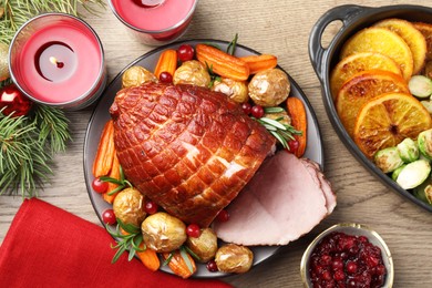 Photo of Christmas food. Tasty baked ham served on wooden table, flat lay