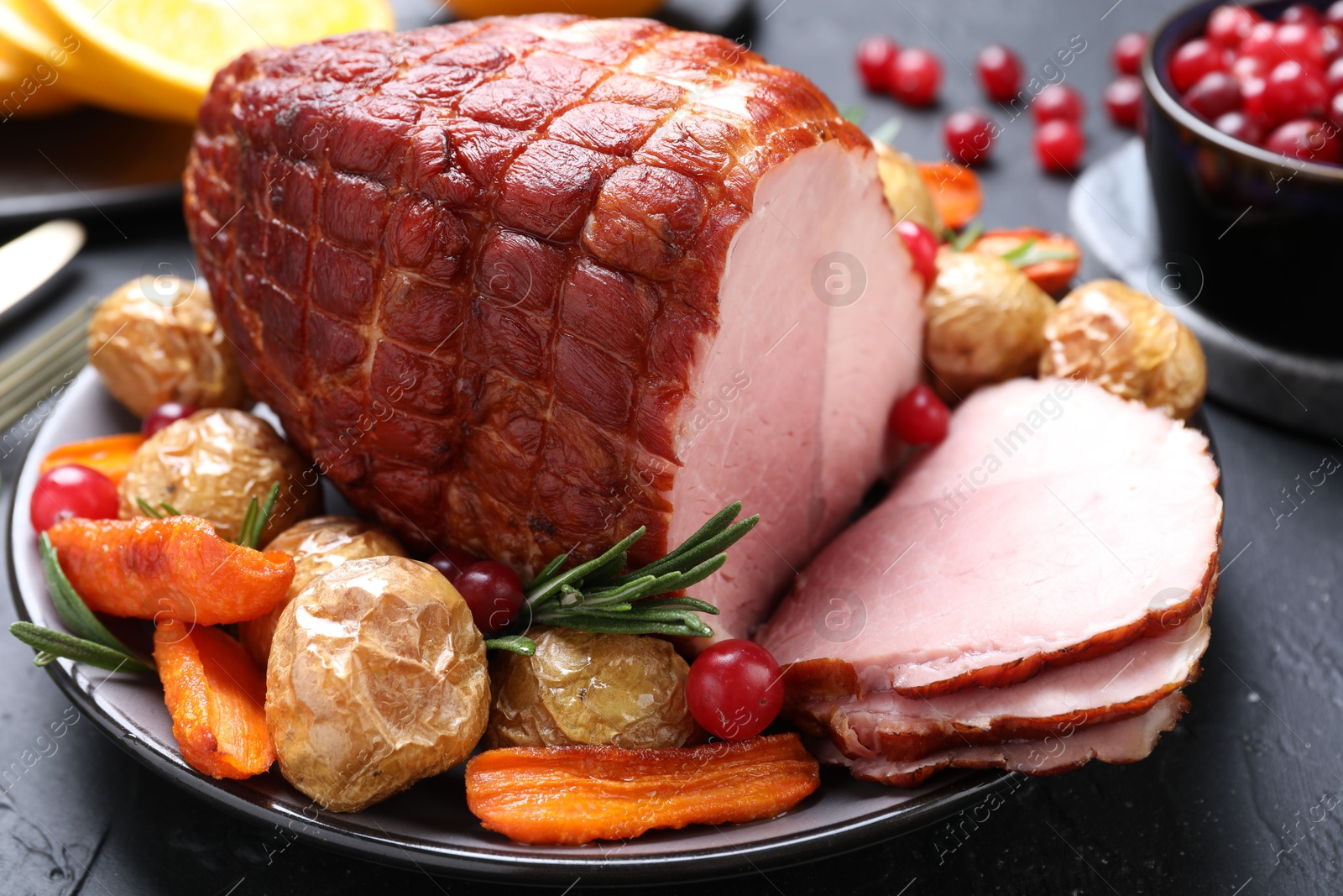 Photo of Christmas food. Tasty baked ham served on black table, closeup