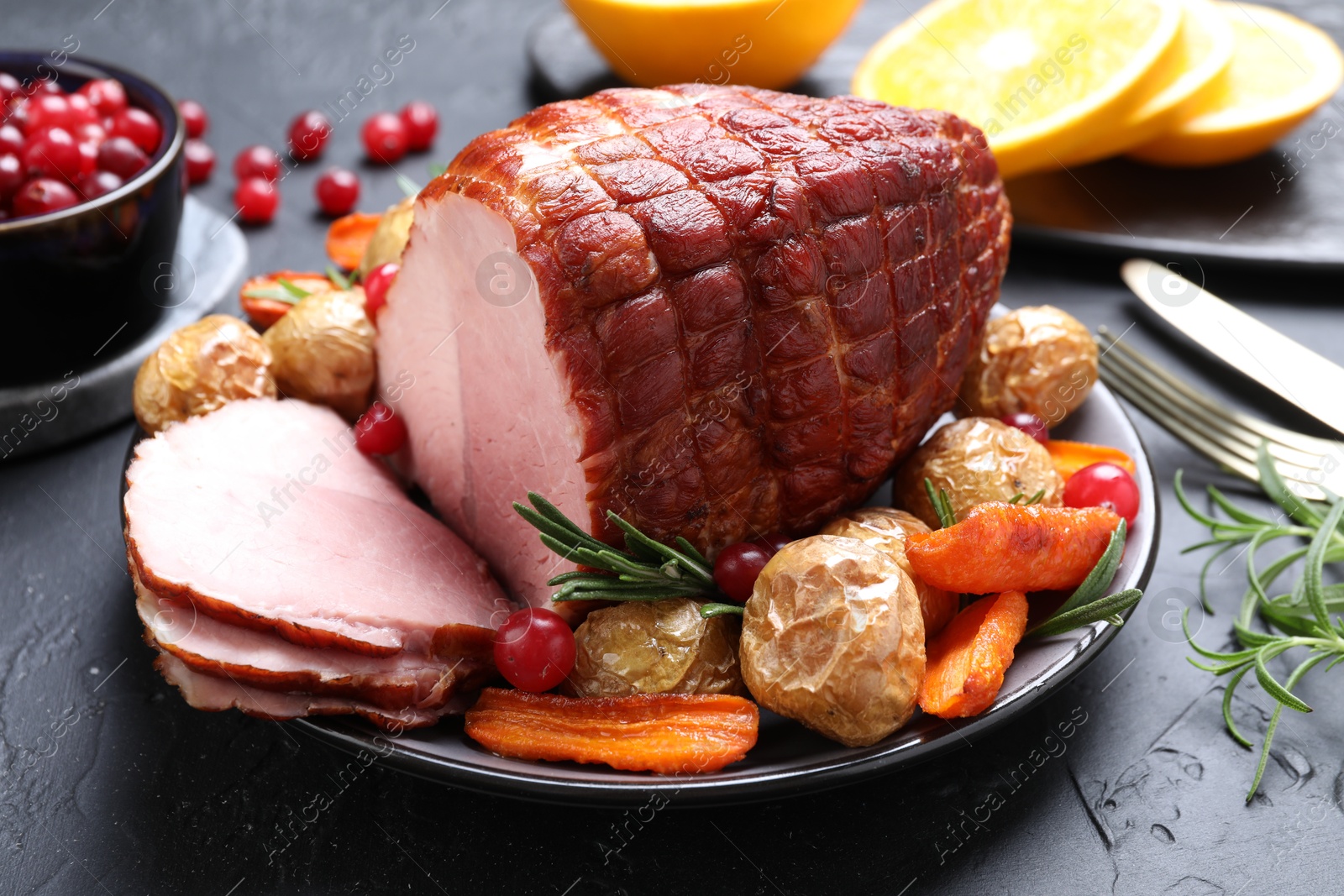 Photo of Christmas food. Tasty baked ham served on black table, closeup