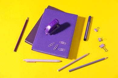 Photo of Different bright stationery on yellow background, above view