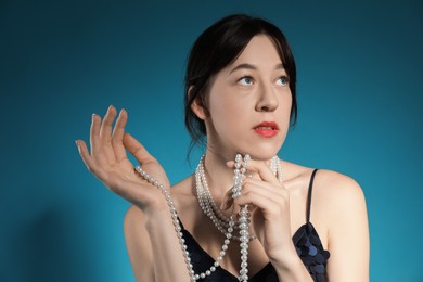 Photo of Beautiful young woman with pearl jewelry posing on blue background