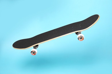 Photo of One skateboard on light blue background. Sports equipment